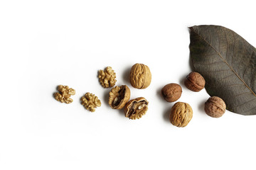 Walnut kernels half and whole with tree leaf isolated on white background