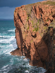 Obraz premium Sea cliffs near North Ham on Muckle Roe, Shetland, UK - the rock is of the Muckle Roe Intrusion - granite, granophyric - igneous bedrock formed in the Devonian Period. 