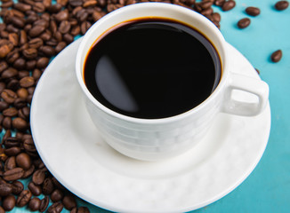 Cup Of Black Coffee With Roasted Coffee Beans On Table