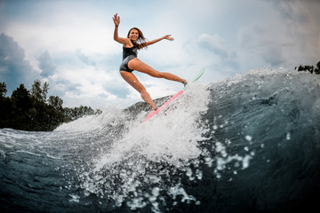 Fototapeta na wymiar Girl wakesurfer making stunts on a board