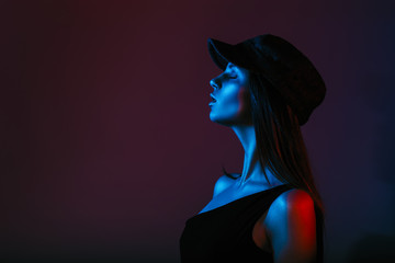 Conception of cyberpunk and futurism. Portrait of young girl in studio shot in dark studio with...