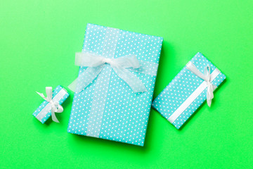 Top view Christmas present box with white bow on green background