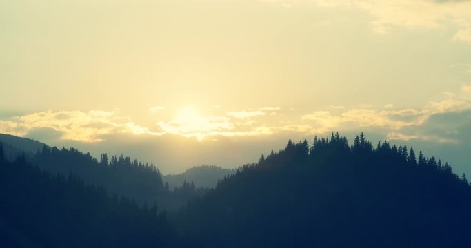 Breathtaking cloud timelapse with sun rays of a sunset in transylvania with hills and amazing details of pine woods in 4k quality