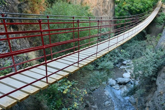 Puente colgante peatonal sobre un r&iacute;o