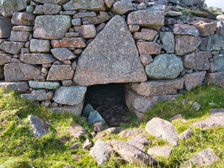 The massive triangular lintel stone over the entrance of the isolated, remote and unexcavated Culswick Broch, on Mainland, Shetland, UK