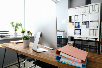 Silver modern computer on wood table against office background. Programming training concept