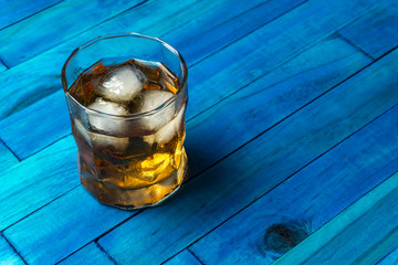 Ron en las rocas sobre fondo de madera azul