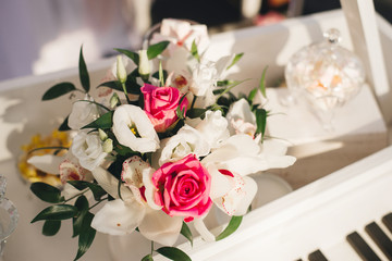 Wedding flower arrangement of white eustoma, Orchid and pink roses in the wedding decor