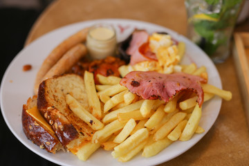 Fried chicken legs,sausage,eggs,with french fries.