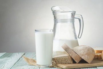 Glass cup and jug of milk, sliced fresh bread