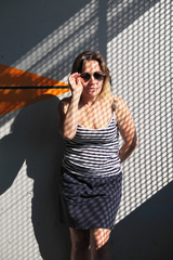 Portrait of a girl in glasses with a pattern of shadows.