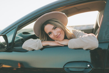 A beautiful woman in the car at sunset.
