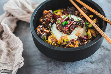 General Tso's Chicken with steamed rice and chopsticks 