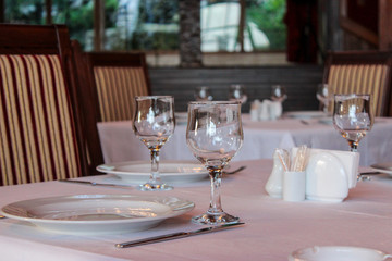 Close-up of wine glasses and plates placed on the table in the restaurant