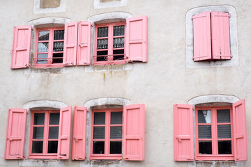 Fototapeta premium beautiful facade with pink windows and shutters