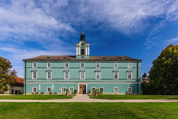 Dacice, Czech Republic - September 29 2019: View of a state-owned castle Dacice from park with green grass and trees. Sunny autumn day with blue sky and white clouds.