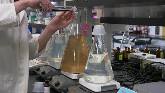 Close-Up 4K Lab Footage: Scientist Mixing Chemicals in a Clear Bottle