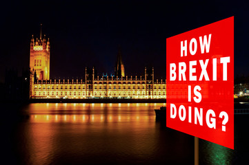 Red board with phrase 'How BREXIT is Doing?'. Brexit Concept with parliament in background at night. London, UK.