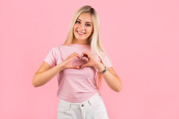 Fototapeta na wymiar beautiful young woman on pink background with hand gesture