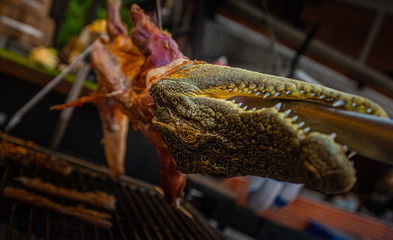 Crocodile meat on the barbeque for sale to tourists in the street on Thailand