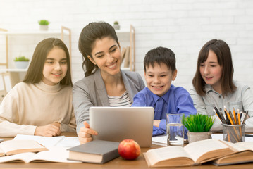 Teacher showing pupils interesting videos on tablet