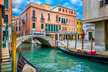 Naklejka na ściany i meble Narrow canal with gondola and bridge in Venice, Italy. Architecture and landmark of Venice. Cozy cityscape of Venice.
