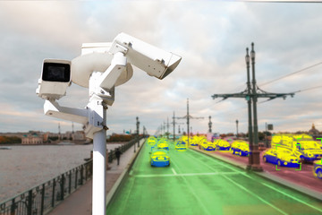 The concept of video surveillance and security technology. A surveillance camera monitors the violators of traffic rules. In the background, the road of different congestion