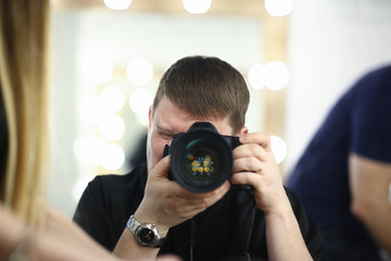 A male photographer holds camera in his hand concept. The self-portrait is reflected in the mirror.