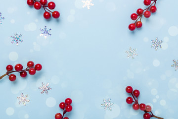 Christmas composition Snowflakes and holly berries on pastel blue background. Christmas, winter,...