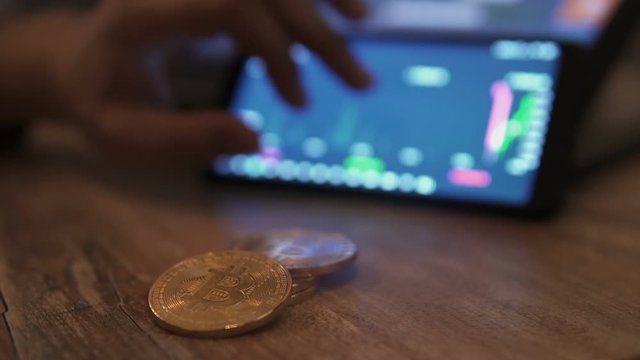 Real bitcoin coins on table. Block-chain, trading online, Cryptocurrency trend graph. Man touching screen, chart. Forex. Crypto currency. Bitcoin cryptocurrency. Candle graph. investment