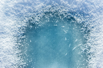 Winter background: close-up of frozen ice with snow crystals and snowflakes. Christmas and Happy...
