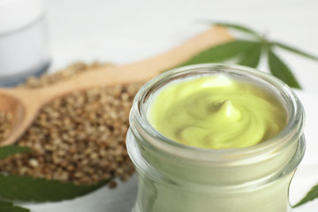 Obraz na płótnie Canvas Jar of hemp cream on table, closeup. Organic cosmetics