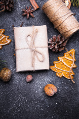 Christmas background with decorations. Christmas presents, gingerbreads, pine twigs and cones covered with snow on dark background