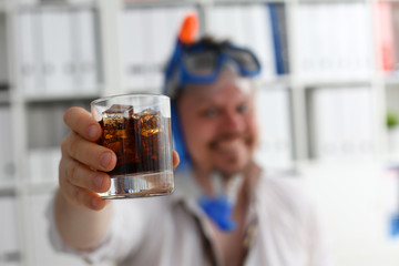 Man wearing suit and tie in goggles and snorkel hold in arm glass of cola at workplace in office closeup. Count days to leave annual day off workaholic resort idea ticket sale concept