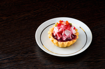 Basket-cake with jam on the plate on dark background