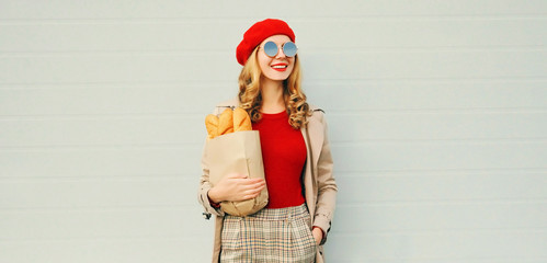 Portrait happy young smiling woman looking away holding grocery shopping paper bag with long white...