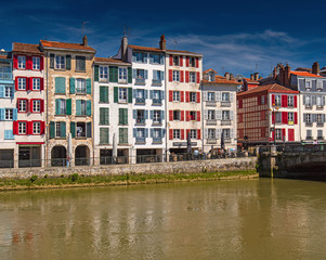 Fototapeta na wymiar Colorful houses at the Nive river embankment in Bayonne, France