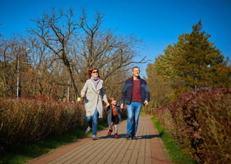 cheerful family walks in the autumn park