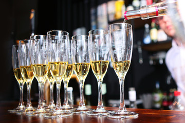The bartender pours white wine into a glass. Wine tasting concept. Unrecognizable photo. Photo without a face.