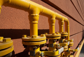 yellow pipes on a brick wall.