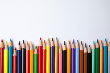 Composition with color pencils on white background, top view