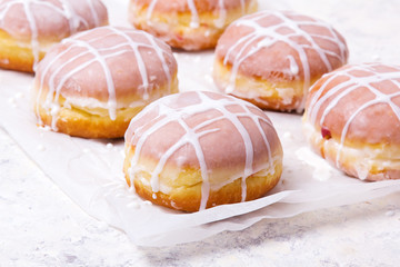 Traditional Polish donuts with white frosting on white background. Tasty doughnuts with jam.
