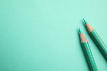 Flat lay composition with color pencils on turquoise background. Space for text