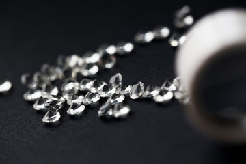 Scattering of white star diamonds on black background table jeweler concept