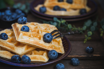 Belgian waffles with blueberries, on a dark background.