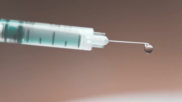 medical syringe with injection solution drop.