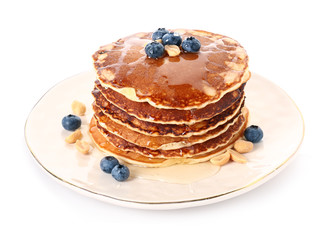 Plate with tasty pancakes and blueberries on white background