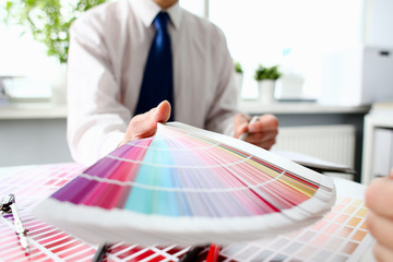 Employee refueling cartridge service holds magnifying glass in hand. Color print of pantone...