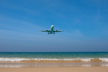 Fototapeta na wymiar The plane lands on landing over Mai Khao Beach in Thailand. Under the plane is a beautiful beach with clean sand and blue sea.