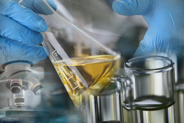 Male hands in protective gloves hold test tube in hands produces chemistry test of motor oil...